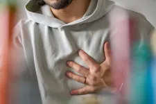 Ung man som håller sig för hjärtat. Foto: iStock