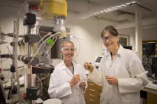 Två kvinnliga forskare i vita rockar i laboratorium.
