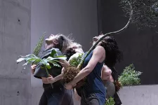 Dansare håller i växter under performance