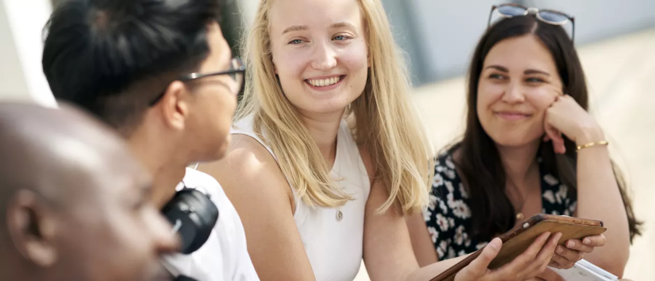 Fyra studenter som är glada utomhus. Foto.