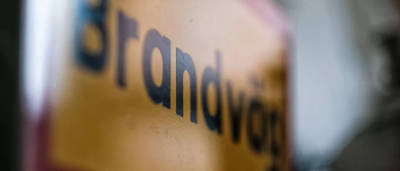 Närbild skylt “Brandvägg”. Foto.