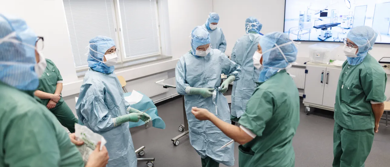 Operationssjuksköterskor som klär sig för operation. Foto