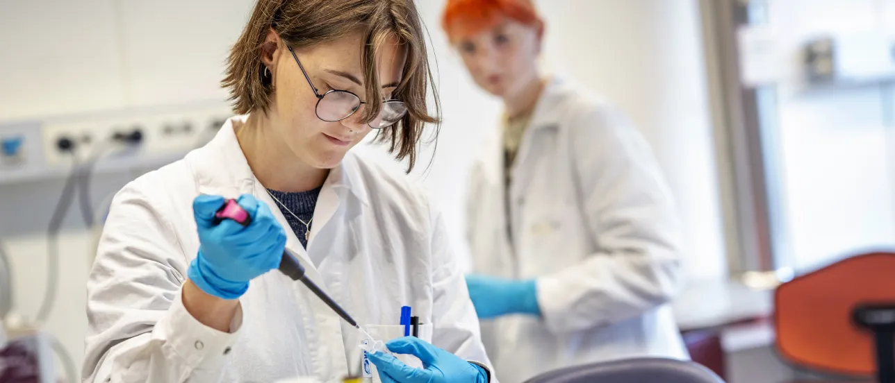 Foto. Student vid dragskåp.