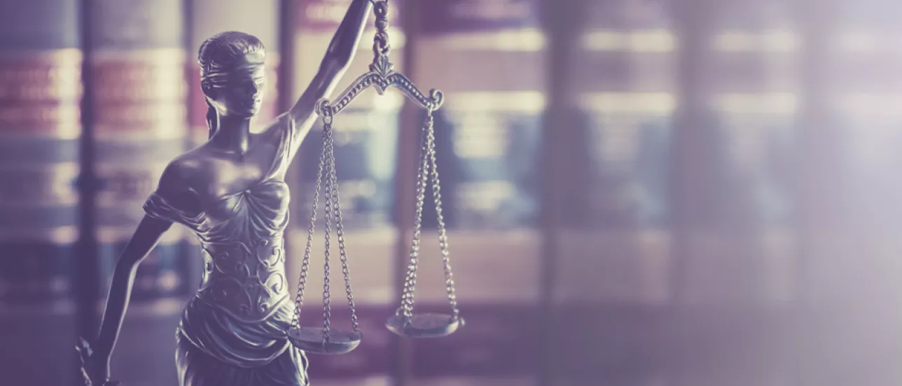 Bilden visar Justitia, rättvisans gudinna, framför lagböcker