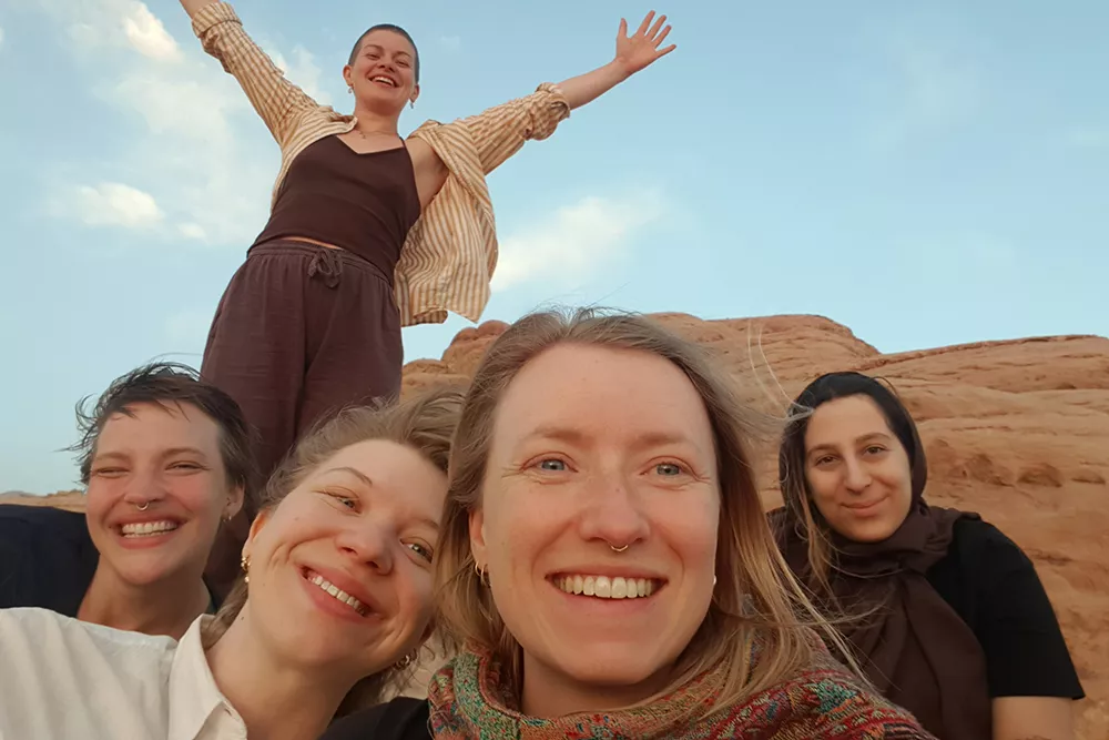 Fyra glada tjejer i öknen, Jordanien. Foto.