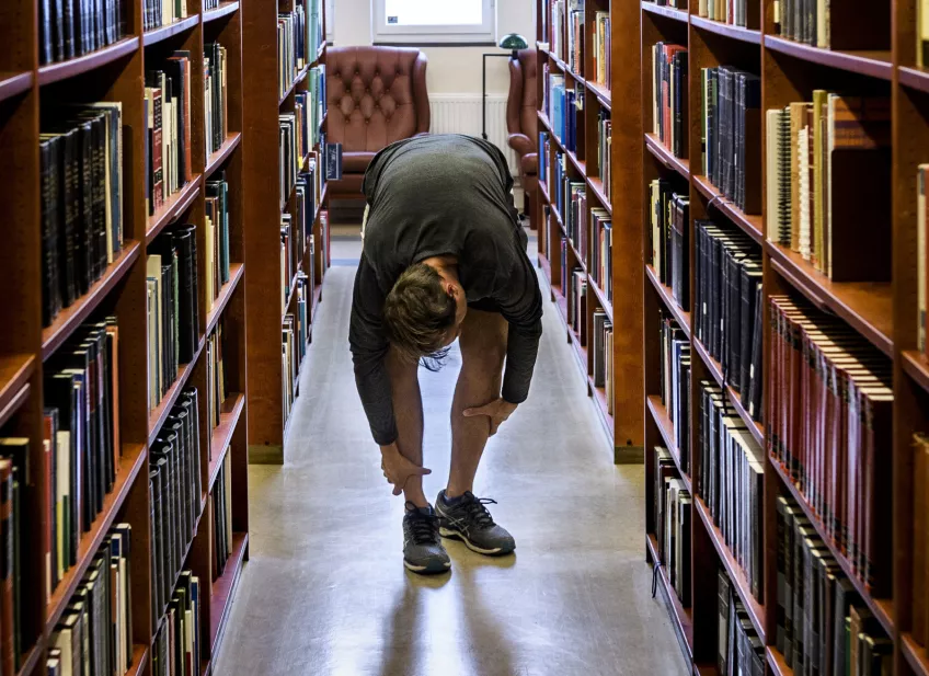 En student letar efter en bok i ett bibliotek. Foto Kennet Ruona.