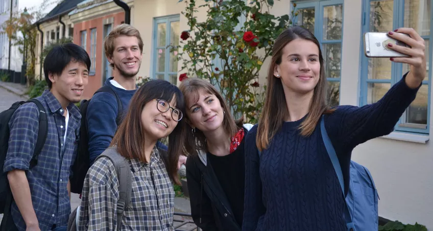 Fyra internationella studenter tar en selfie i Lunds stadsmiljö. Foto.