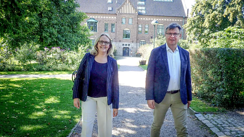En kvinna och en man framför universitetsbibliotek.