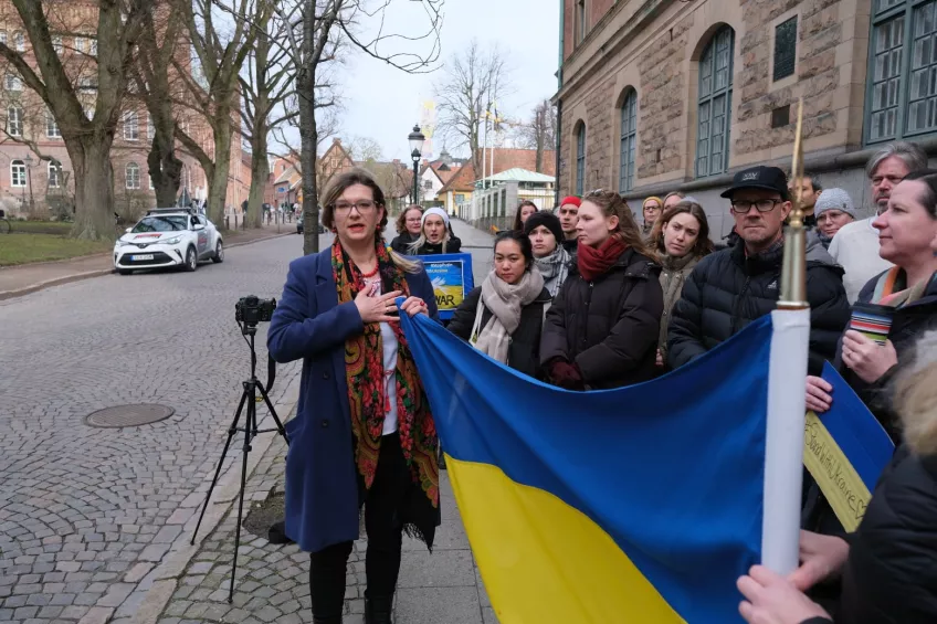 Manifestation utomhus med många människor och den ukrainska flaggan. Foto