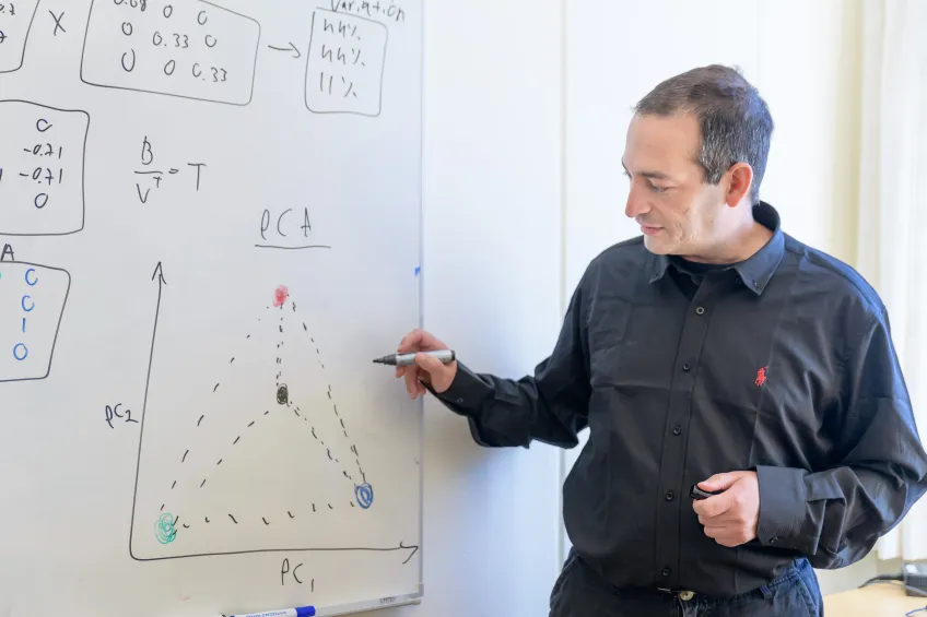 Manlig forskare skriver på en whiteboard.