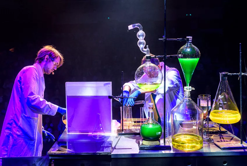 Två kemister utför experiment på en scen. Foto.