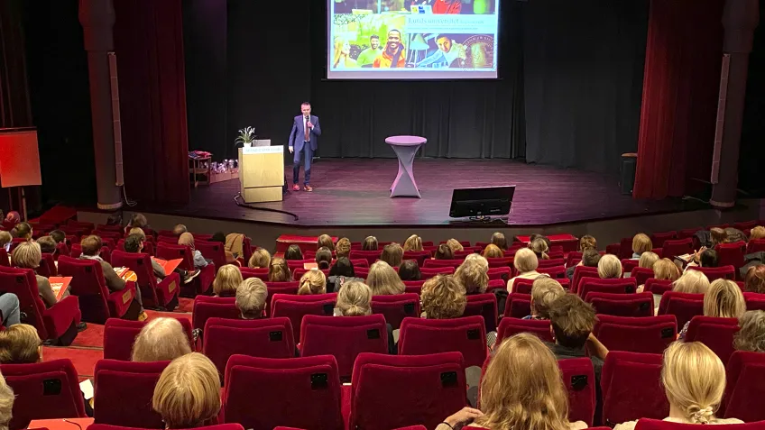 Publik tittar på en man på en scen. 