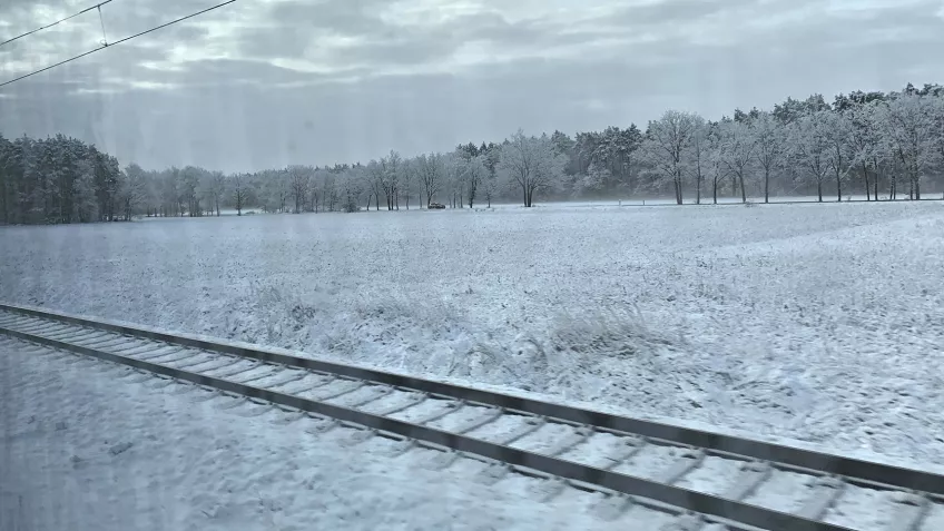 Utsikt från tåg över snöigt landskap. Foto.