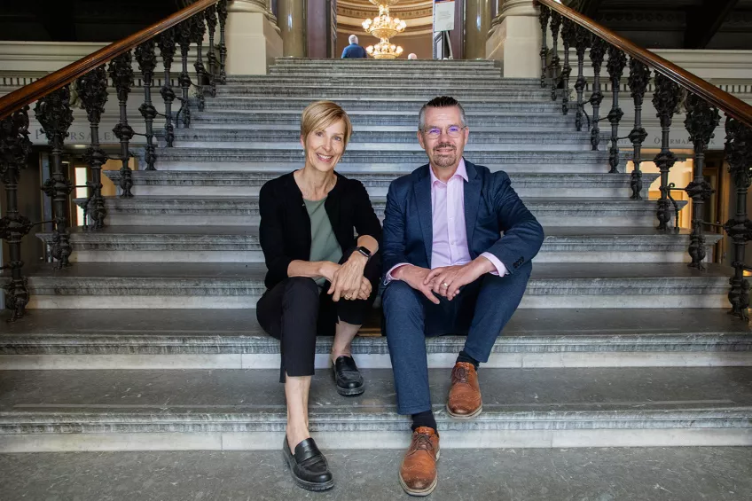 Erik Renström och Lena Eskilsson sitter i trappan inne vid universitetshusets foajé. Foto: Charlotte Carlberg Bärg.