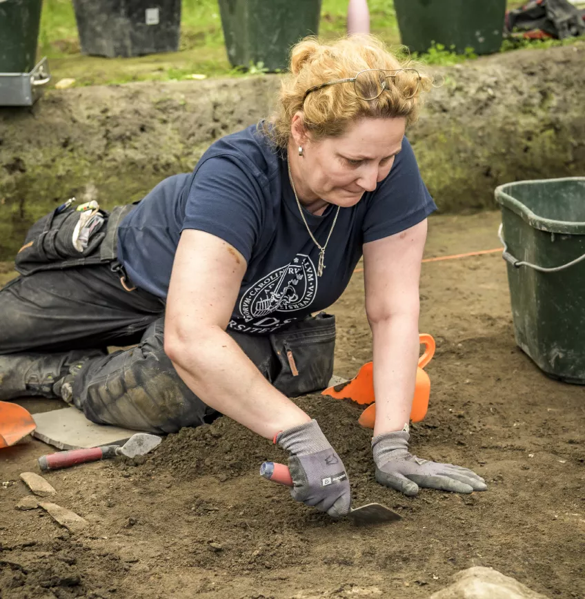 Kvinna gräver i jorden. Foto. 