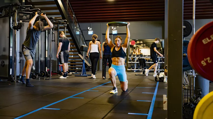 Foto inifrån Gerdahallens gym där ett flertal personer styrketränar.