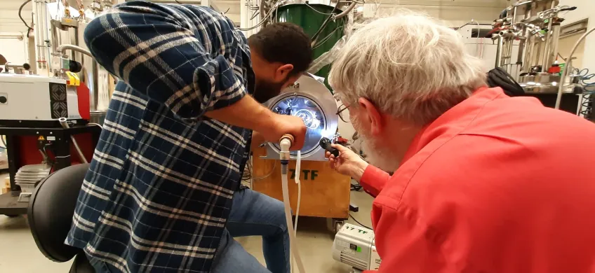 Två manliga forskare vid en så kallad kryomagnet.