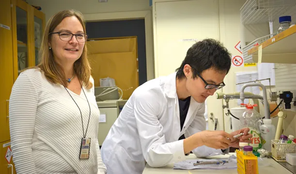 Kvinna och man i vit rock i laboratorium