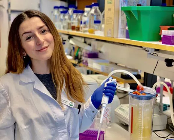 Biomedicinstudenten Liza står i labbrock i ett laboratorium
