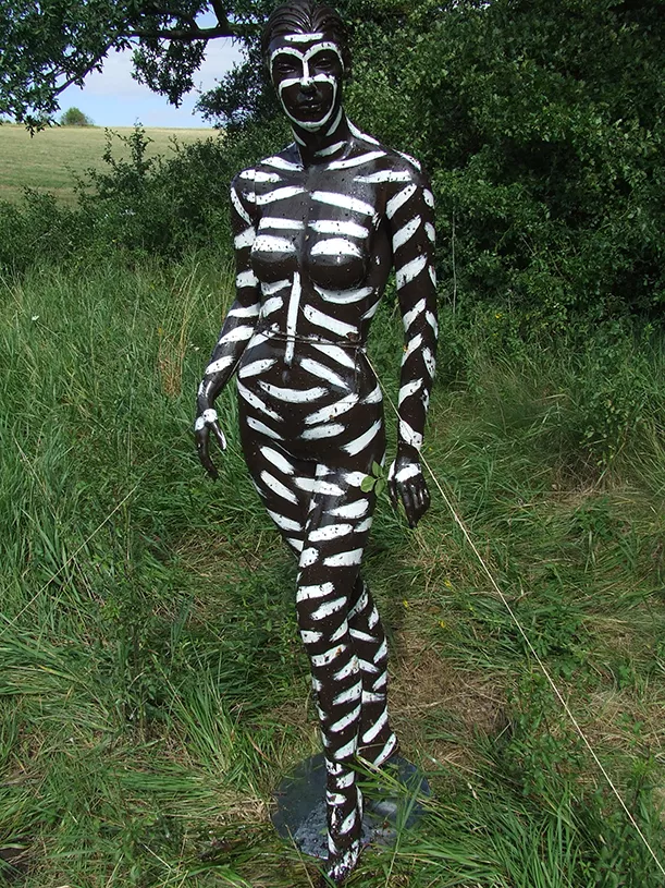 Kroppsmålad plastmodell av en människa. Vita streck på mörk bakgrund.  