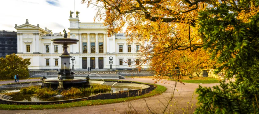 Universitetshuset en solig novemberdag med fontänen i förgrunden.