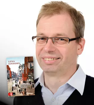 Porträtt av man med infällt bokomslag. Foto.
